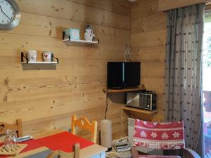 een kamer met een houten muur met een tafel en een televisie bij Appartement Saint-Jean-d'Aulps, 2 pièces, 4 personnes - FR-1-573-101 in Saint-Jean-dʼAulps