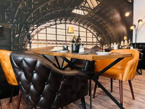 a bar with a wooden table and leather chairs at Designhotel Central Fulda in Fulda