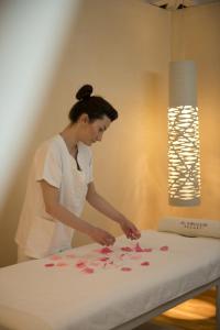 a woman in a kitchen arranging hearts on a table at Al Mirador Resort in Selva di Fasano