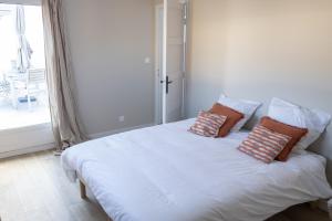 a bedroom with a white bed with pillows on it at Maison de vacances-La balade des deux Caps in Audinghen