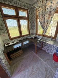 a bathroom with a sink and two windows at Bagamoyo Home Stay in Bagamoyo