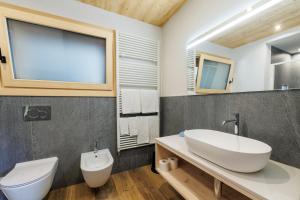 ein Badezimmer mit einem weißen Waschbecken und einem WC in der Unterkunft Hotel Miravalle in Valdidentro