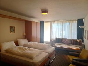サンモリッツにあるAllod Bad 602のベッド2台とソファが備わるホテルルームです。