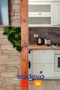 a kitchen with white cabinets and a brick wall at Palace of Culture Dream Apartments and Studios Iasi in Iaşi