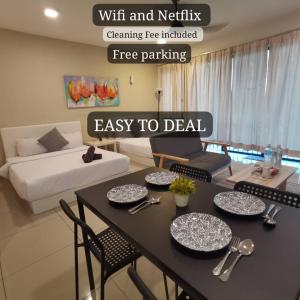 a living room with a table and chairs and a couch at NH Homestay Trefoil Setia Alam in Shah Alam