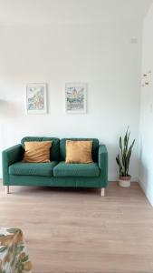 un divano verde in un soggiorno bianco di Casa Vacanze Imma a Sorrento