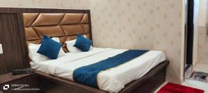 a bedroom with a large bed with blue pillows at HOTEL PLUTUS in Lucknow