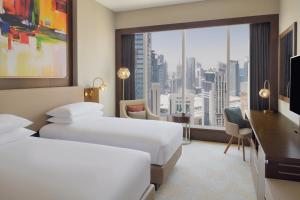 a hotel room with two beds and a large window at Delta Hotels by Marriott City Center Doha in Doha