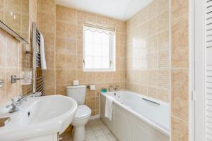 uma casa de banho com uma banheira, um WC e um lavatório. em Chimneys em Poole