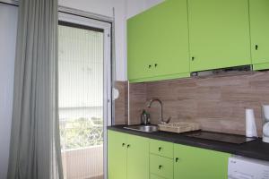 een keuken met groene kasten, een wastafel en een raam bij Athens City Themis 16 in Athene +25 foto's