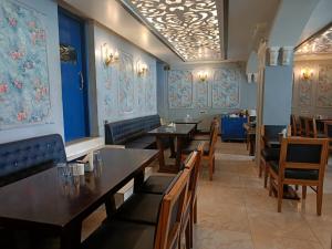 restauracja ze stołami i krzesłami oraz niebieskimi ścianami w obiekcie Maya Hotel & Restaurant w mieście Agra