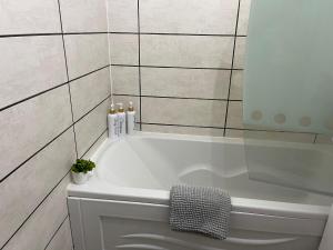 La salle de bains est pourvue d'une baignoire blanche et de carrelage. dans l'établissement Appartement Villiers sur Morin proche de Disneyland, à Villiers-sur-Morin 38 autres photos