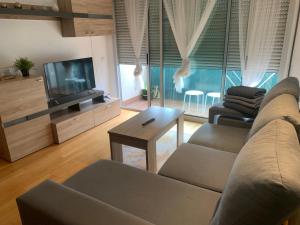 a living room with a couch and a tv at APARTAMENTO NUEVA CONSTRUCCIÓN EN CENTRO CALELLA in Calella