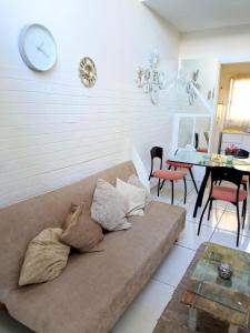 ein Wohnzimmer mit einem Sofa und einer Uhr an der Wand in der Unterkunft Recoleta Loft con Terrazas in Buenos Aires