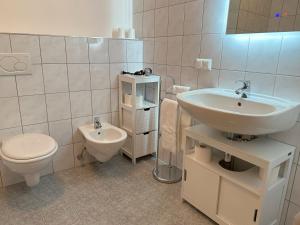 HAUS CLARA by ISA Badkleinkirchheim في باد كلينكيرشهايم: حمام أبيض مع حوض ومرحاض