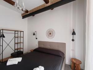 um quarto com uma cama num quarto com paredes brancas em La tua casa a ViadelCorso em Roma