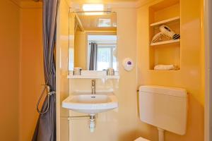 a bathroom with a sink and a toilet and a mirror at Hôtel François d'O in Caen