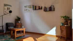 uma sala de estar com uma mesa e livros na parede em ALPINO B&B em Chiesa in Valmalenco