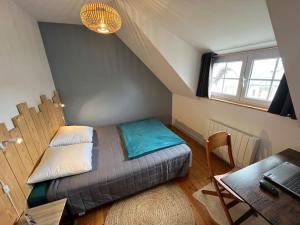 a bedroom with a bed and a desk with a laptop at Le nid in Le Pouliguen