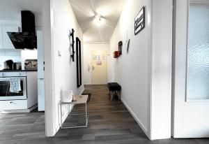 a hallway of a kitchen with white walls and wooden floors at #VAZ Apartments RS06 Küche, WLAN, TV, Balkon in Remscheid