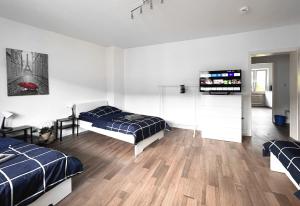 a bedroom with two beds and a flat screen tv at #VAZ Apartments RS06 Küche, WLAN, TV, Balkon in Remscheid