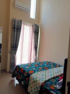 a bedroom with a bed and a window at Villa Kayana Regency F9 Batu in Karangploso