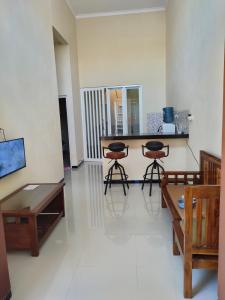 a living room with a table and two stools at Villa Kayana Regency F9 Batu in Karangploso +4 photos