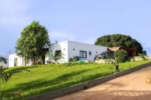 a house with a green lawn in front of it at Standard Room in Cape Coast - Lakeview by Agnes in Cape Coast