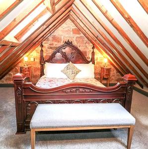 a bedroom with a wooden bed in a attic at Stable Lodge in Berwick-Upon-Tweed