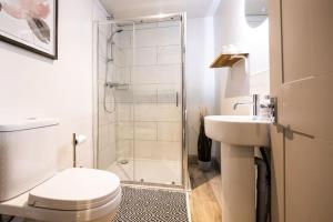 a bathroom with a shower and a toilet and a sink at 3 Castle Mews in Salisbury