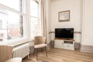 a living room with a television and a chair at 3 Castle Mews in Salisbury