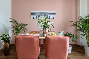 une table à manger avec des chaises roses et des plantes dans l'établissement Hotel A4 Wrocław - Bielany - MAMY WOLNE POKOJE !, à Bielany Wrocławskie