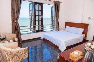 um quarto com uma cama e vista para o oceano em Khách sạn Hương Phong em Vung Tau