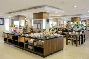 a restaurant with a counter with dishes on it at Hotel Gunawangsa Manyar in Surabaya