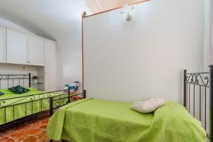 - une chambre avec 2 lits et une couverture verte dans l'établissement Dimora degli Angeli by BarbarHouse, à Gallipoli
