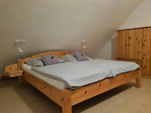 a bedroom with a wooden bed with pillows at Ferienwohnungen "Zum Lochfeld" in Wittersheim