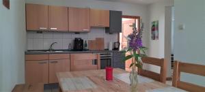 a kitchen with a wooden table with a vase of flowers at Ferienwohnungen "Zum Lochfeld" in Wittersheim