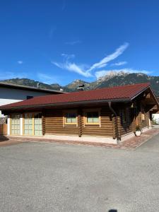 una cabaña de madera con montañas en el fondo en Burgchalet en Reutte