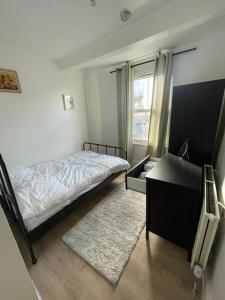 - une chambre avec un lit, un bureau et une fenêtre dans l'établissement Islington Apartments, à Londres
