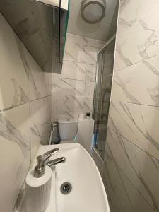 uma casa de banho branca com um lavatório e um WC em Islington Apartments em Londres