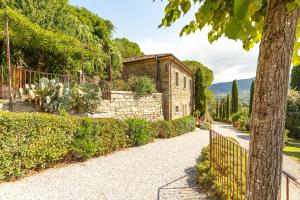 Casa de piedra con valla y jardín en Dolci Colline Resort Capannina, en Castiglion Fiorentino