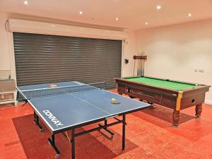 a ping pong table in a room with a pool table at Fulmar in Torpoint