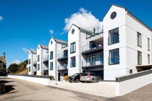 a white building with a car parked in front of it at Fulmar in Torpoint