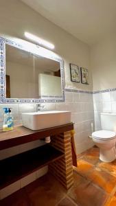 y baño con lavabo y aseo. en Casa Rural La Cordonera en Herguijuela