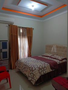 een slaapkamer met een bed en een raam bij Helens Homestay in Enrekang