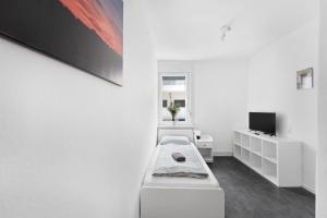 sala de estar blanca con sofá y TV en Schicke Monteurwohnung in Celle, en Celle