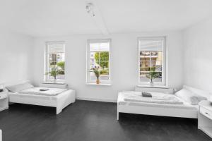 Cette chambre blanche comprend 2 lits et 2 fenêtres. dans l'établissement Schicke Monteurwohnung in Celle, à Celle