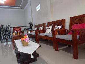 Zimmer mit 4 Betten und einem Tisch mit Blumen in der Unterkunft Helens Homestay in Enrekang