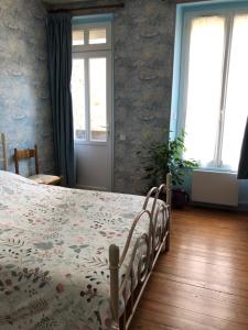 1 Schlafzimmer mit einem Bett mit Blumenbettdecke in der Unterkunft 77 Bleu in Balleroy