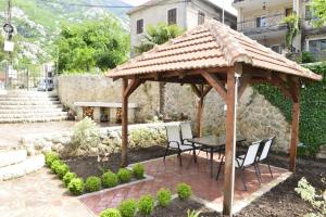einen hölzernen Pavillon mit einem Tisch und Stühlen in der Unterkunft Villa Andrea Apartments with parking in Kotor